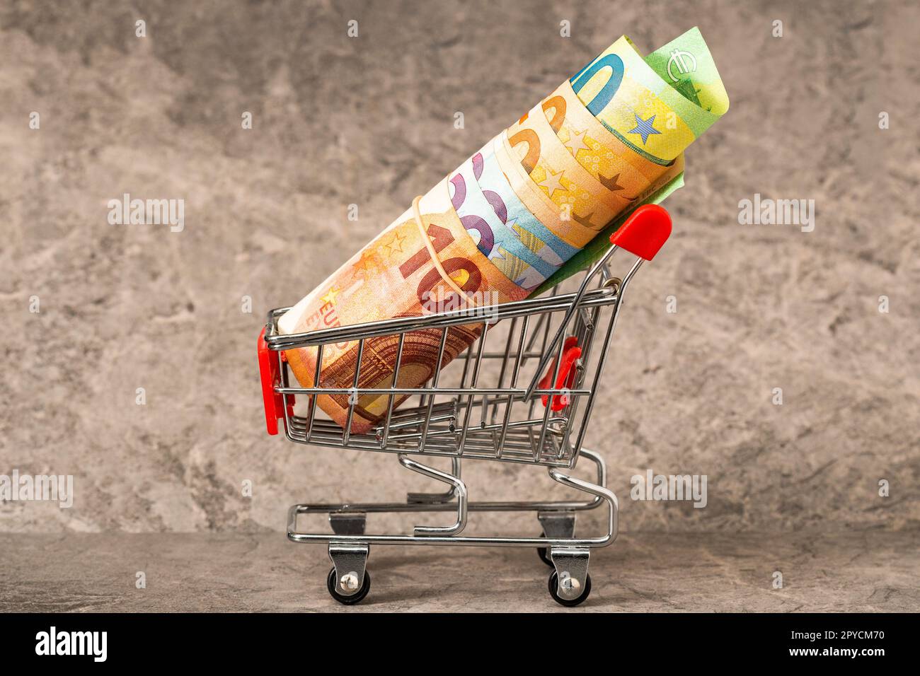 Roll of Euro notes in a shopping cart Stock Photo