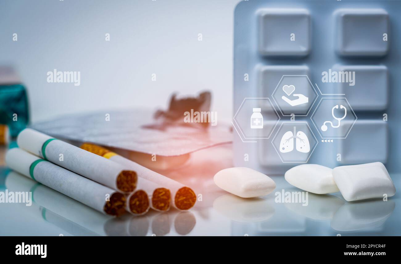 Quit smoking or smoking cessation with nicotine replacement therapy or NRT. 31 May World No Tobacco Day. Nicotine chewing gum in blister pack near pile of cigarettes. Nicotine products to stop smoke. Stock Photo