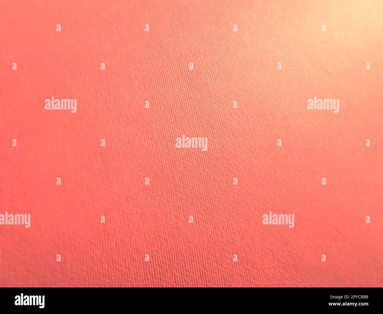 Abstract pink background with texture. Close-up of paper surface with light and color gradient. Side lighting. Soft pastel peach or ruddy tone backdrop. Stock Photo