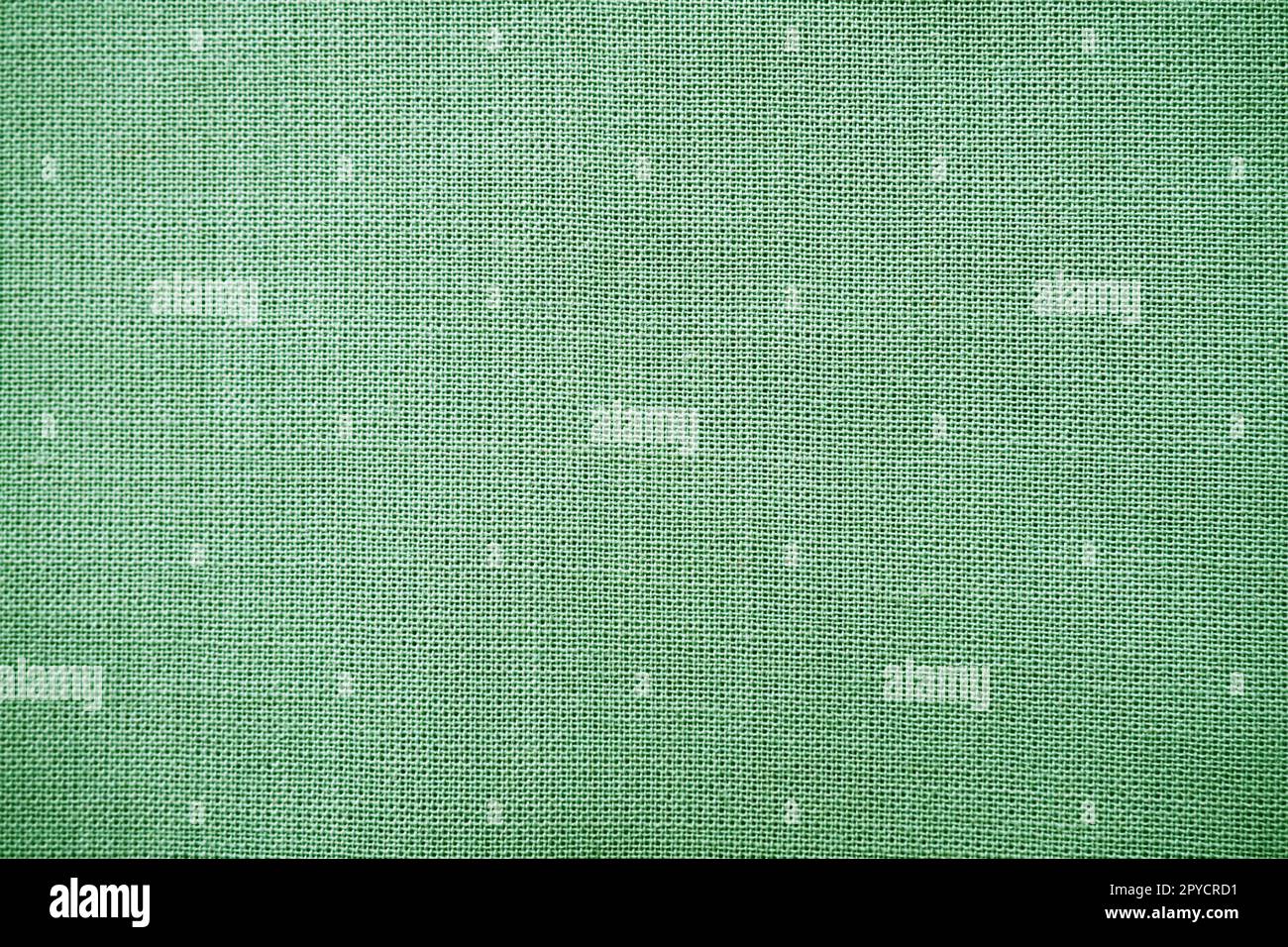 texture of natural green fabric close-up. The texture of the fabric is made of natural cotton or linen textile material. Green canvas background. Smooth surface, smoothed fabric Stock Photo