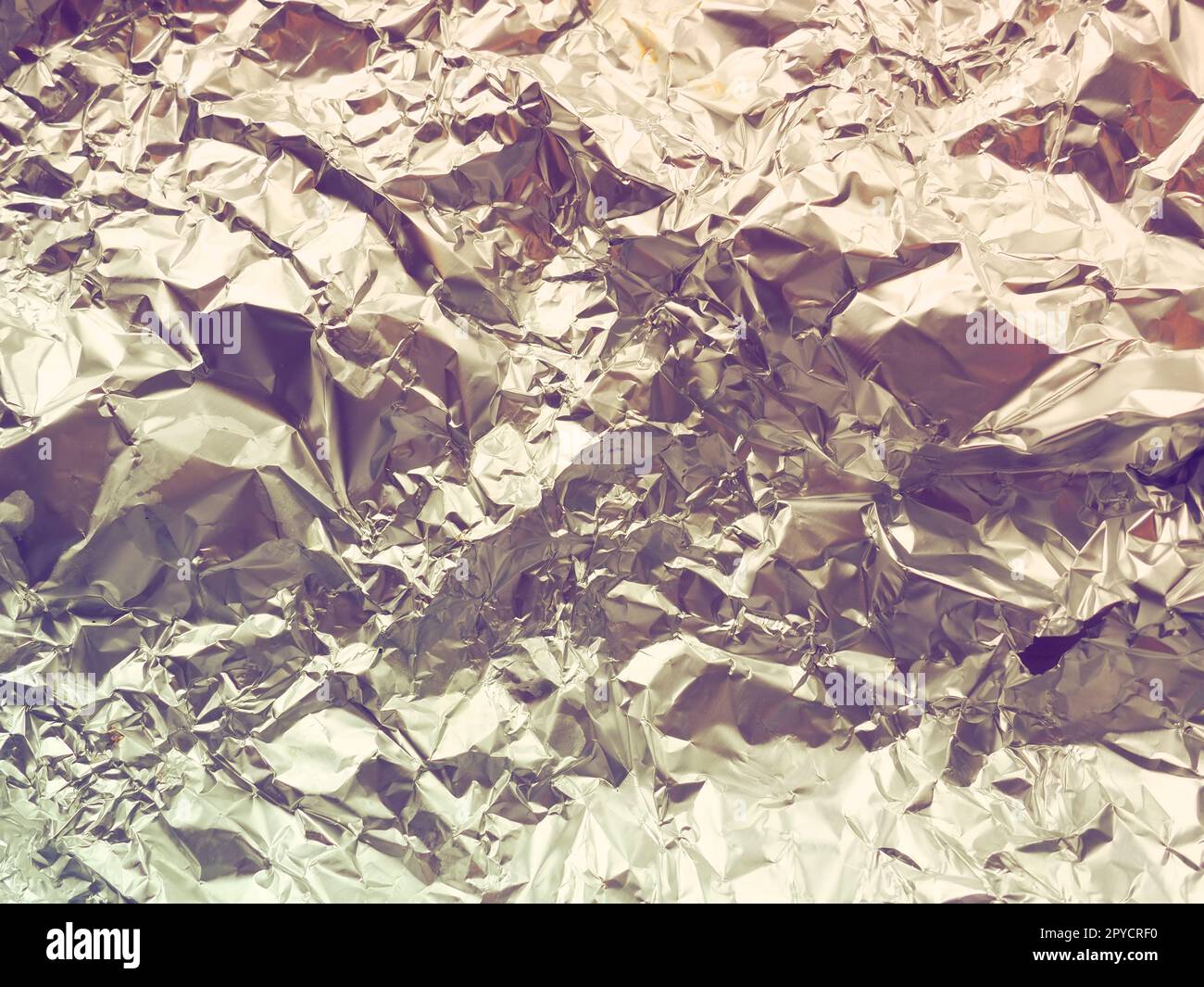 foil close-up. Aluminum gold crumpled foil. Abstract metallic background. Foil for baking food. Background. Retro or vintage style Stock Photo
