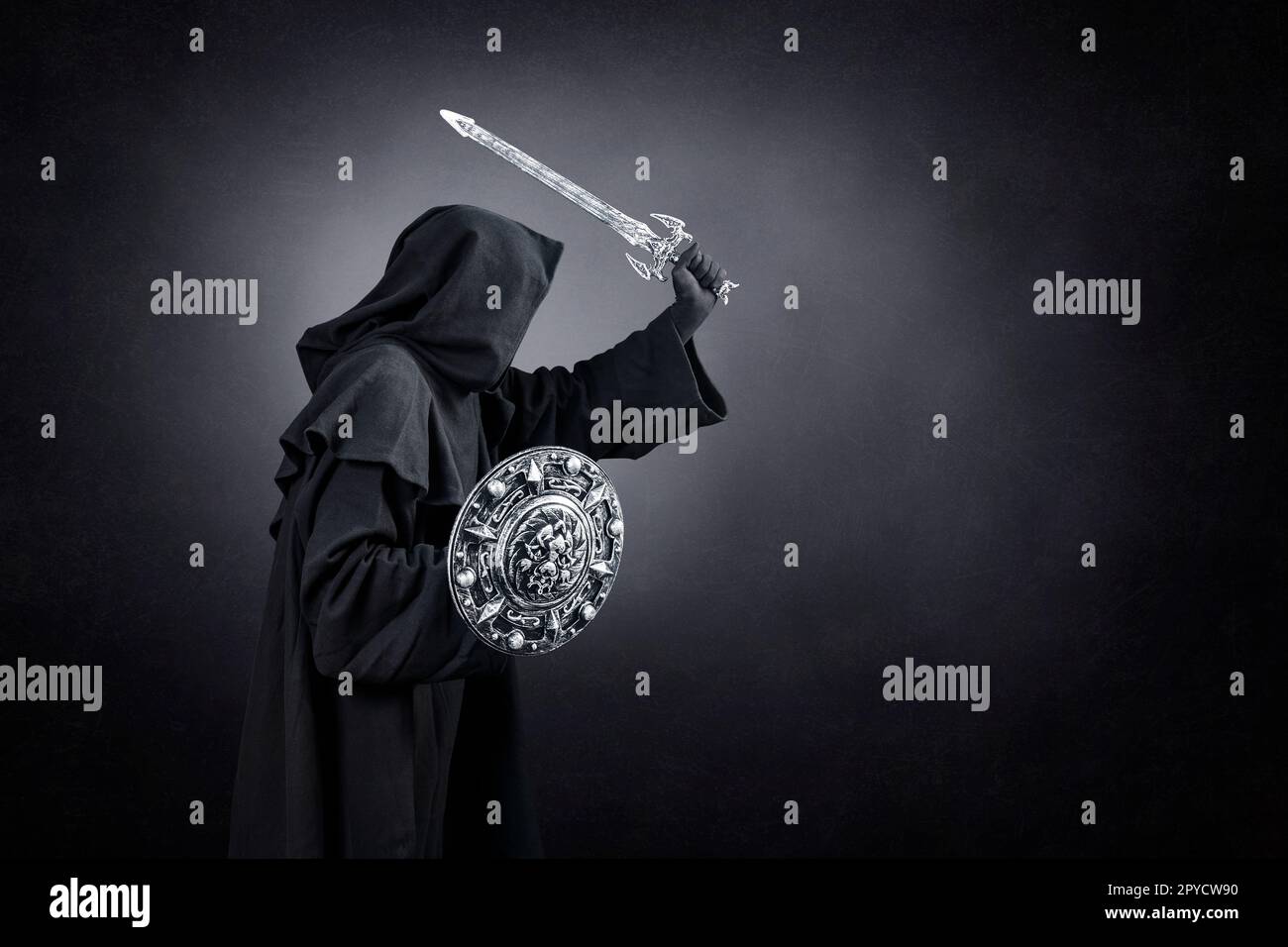 Dark knight with sword and shield over dark misty background Stock Photo