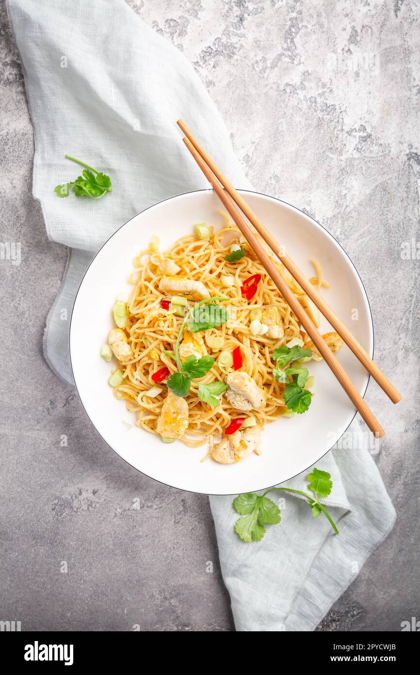 Stir fried noodles with chicken and vegetable in white bowl Stock Photo