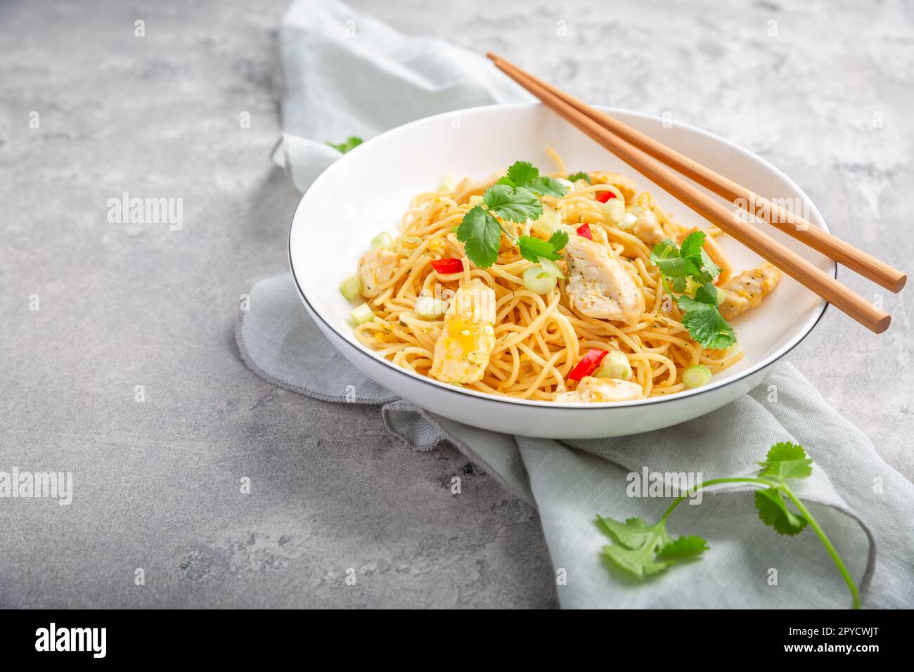 Stir fried noodles with chicken and vegetable in white bowl Stock Photo