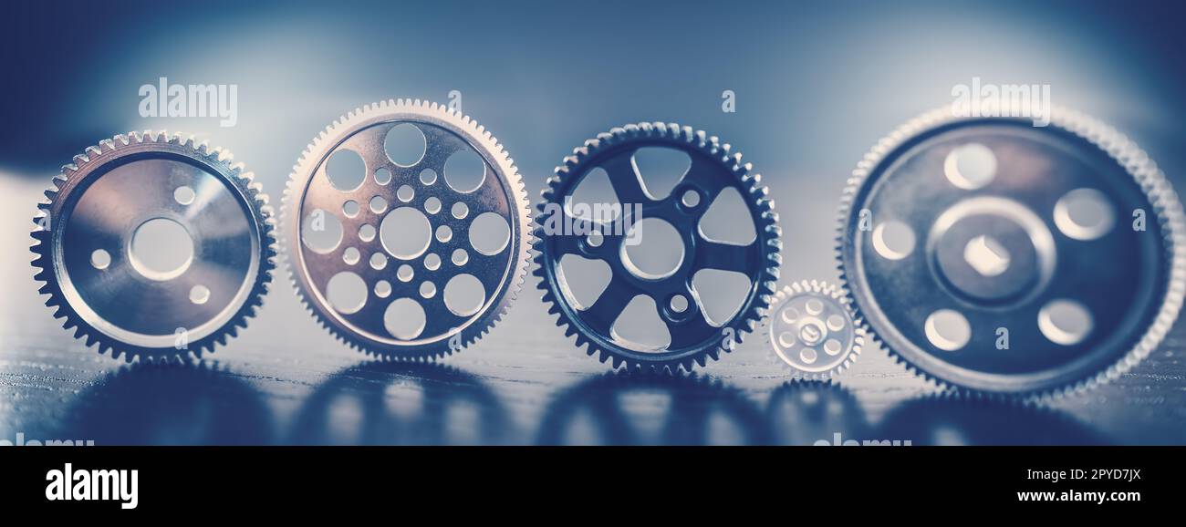 Different shapes cogwheels standing on the black background. Stock Photo
