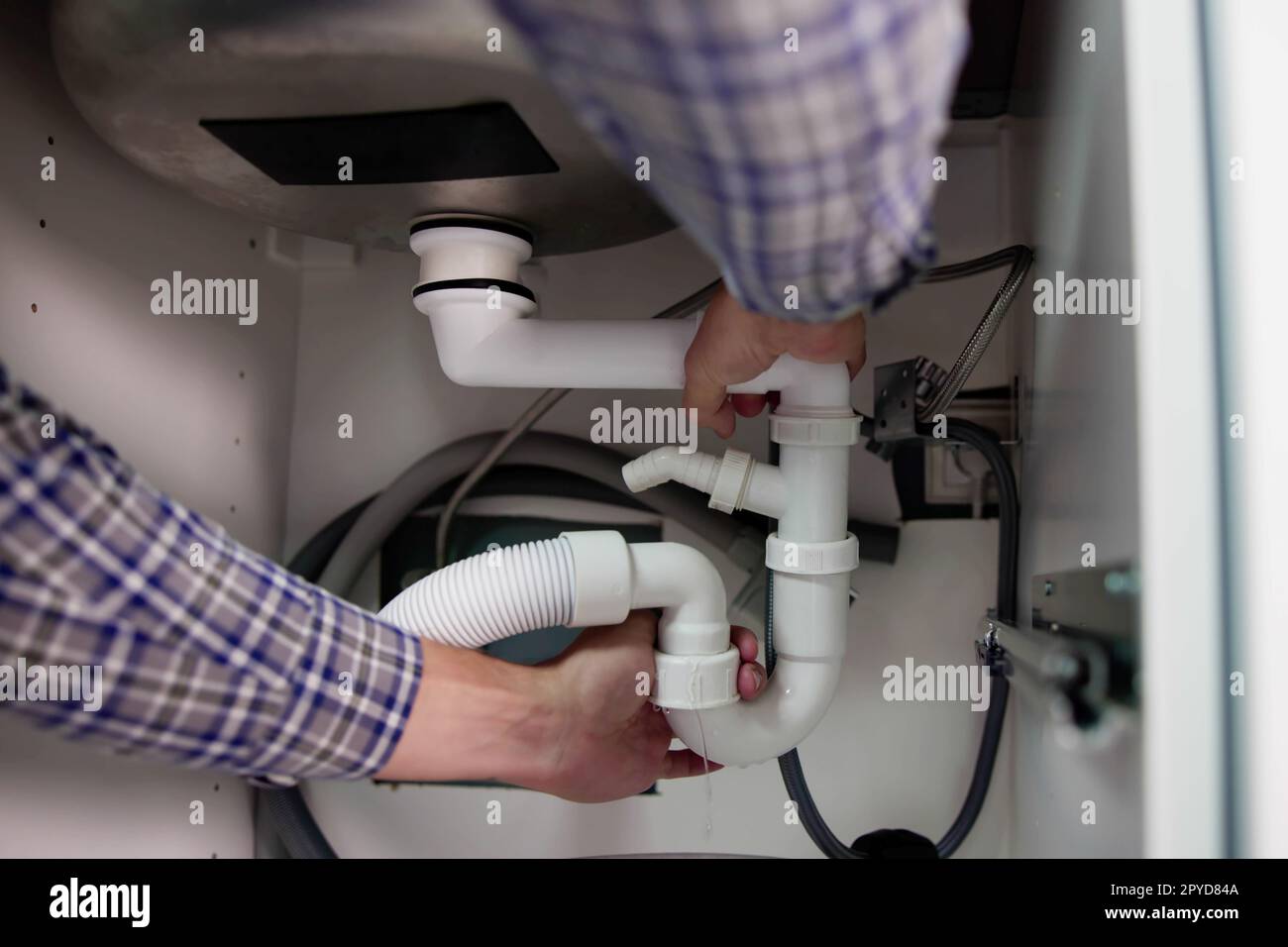 Plumber Fixing Pipe Leak Stock Photo