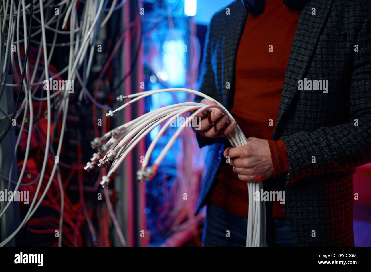IT man with bunch of cables in hands in server room Stock Photo
