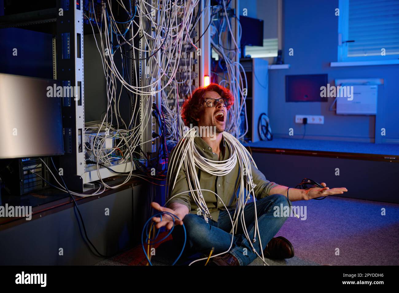 Stressed computer engineer trying to understand network mess Stock Photo
