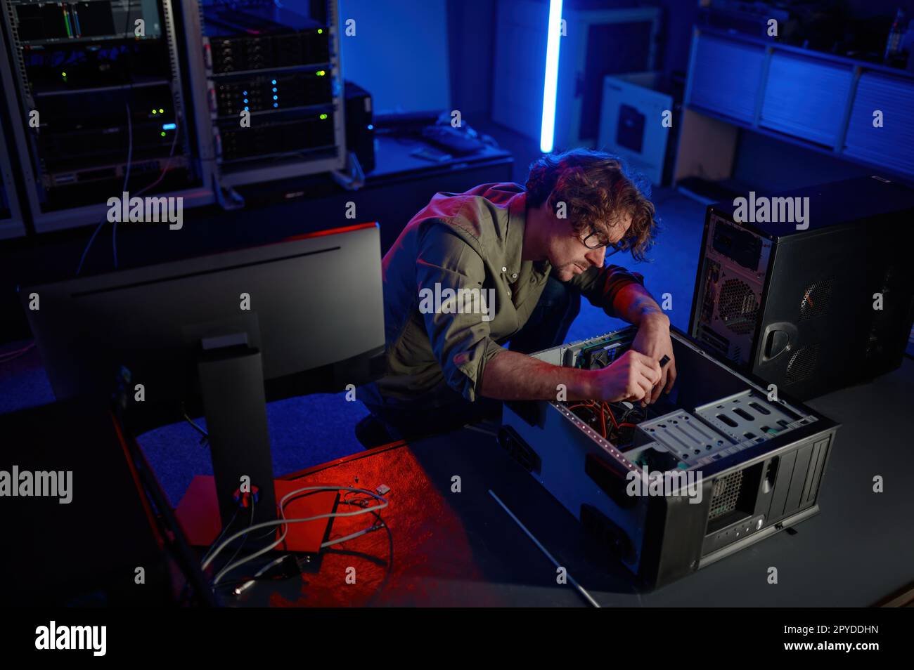 Man repairing computer system unit in modern service center Stock Photo