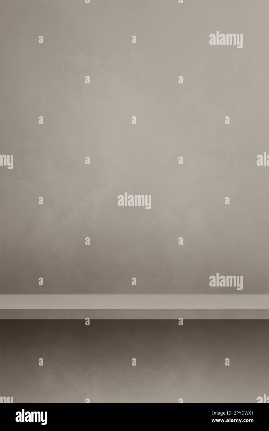 Empty shelf on a warm grey concrete wall. Background template. Vertical mockup Stock Photo