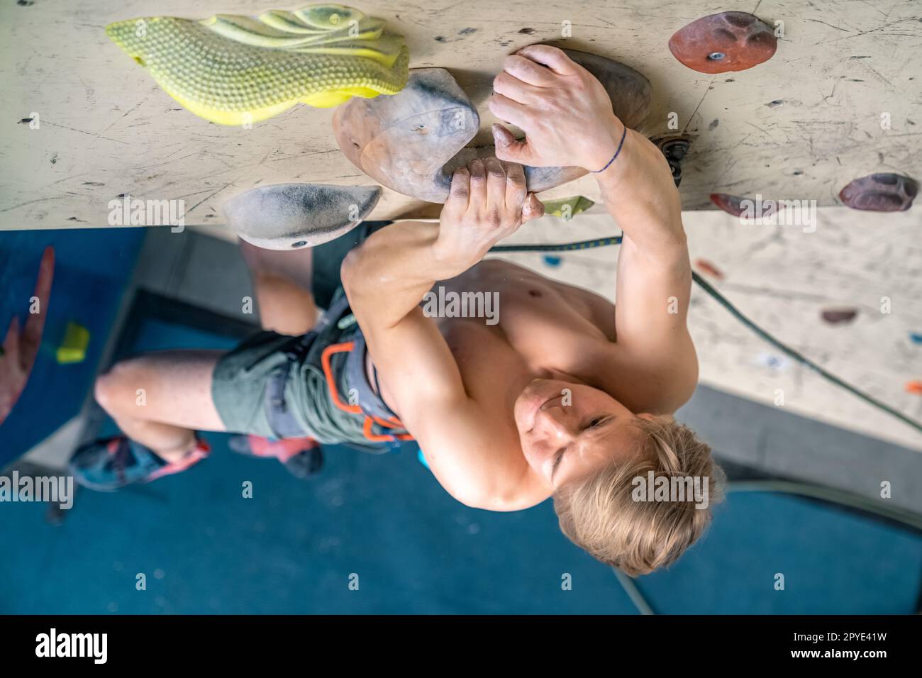 the climber pulls himself onto the wall on the hold Stock Photo