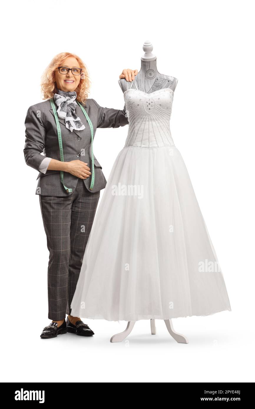 Seamstress posing with a bridal gown on a mannequin doll isolated on white background Stock Photo