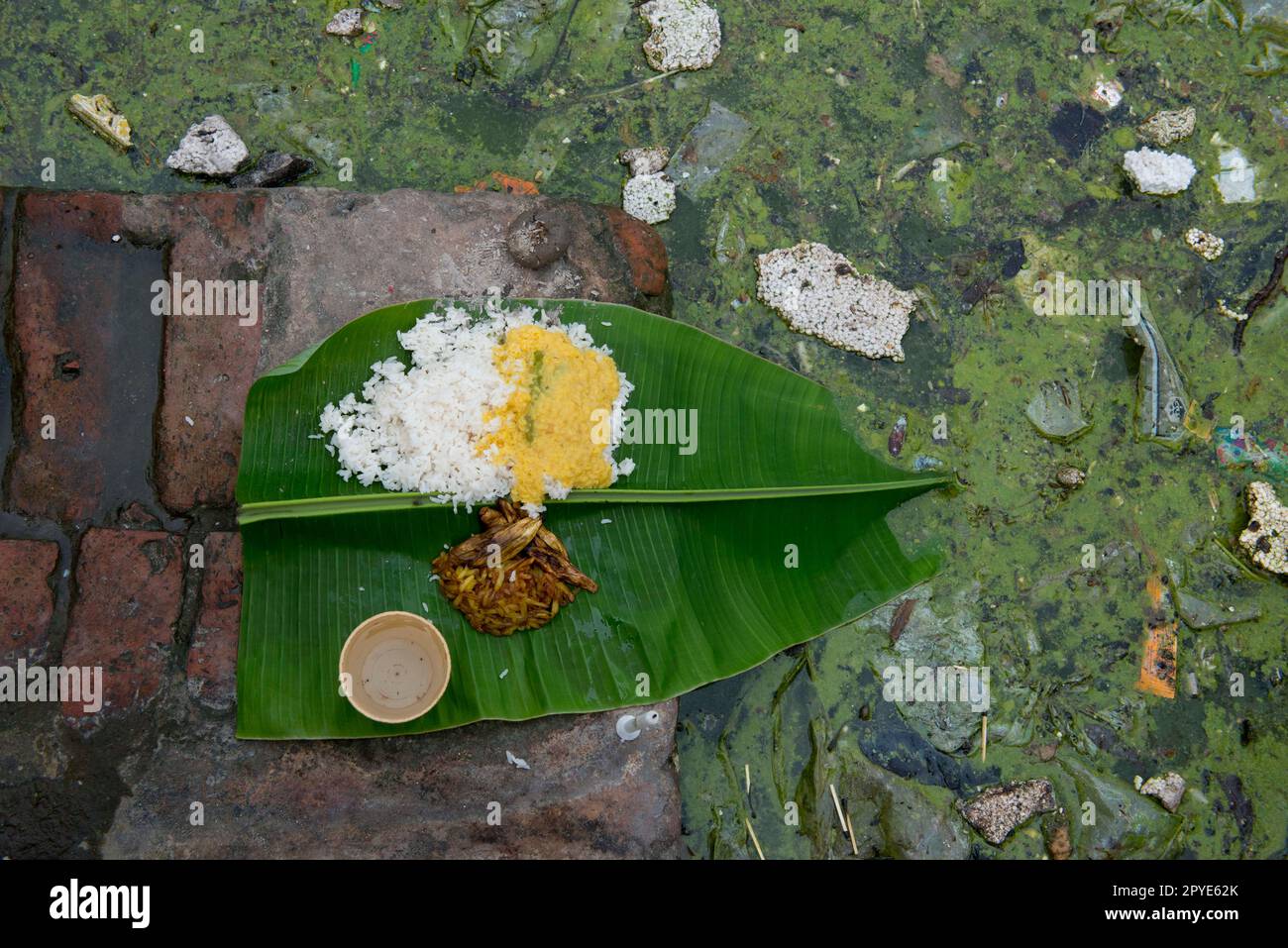 Bangladesh, Khulna, Sonadanga. A Hindu rice offering at the edge of a lake in Bangladesh. January 28, 2012. Stock Photo