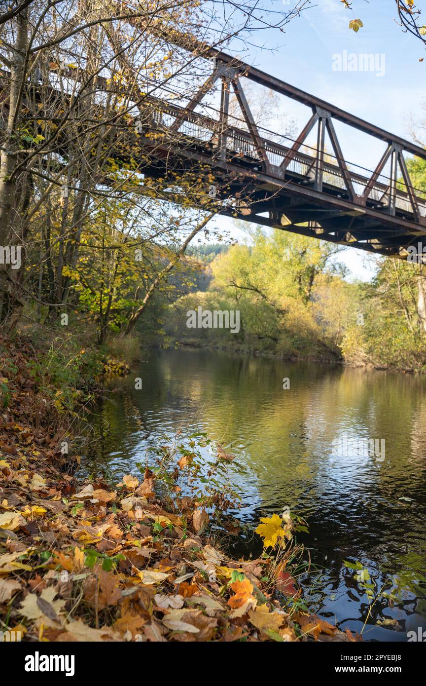 Iron bridge over a river in the autumn nature Stock Photo - Alamy
