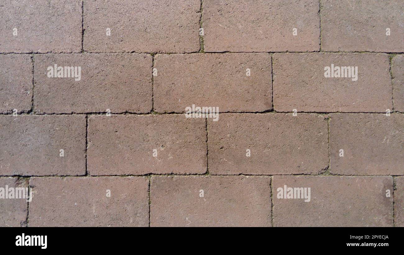 Wall of uneven gray cement blocks. Concrete fence or structure. The