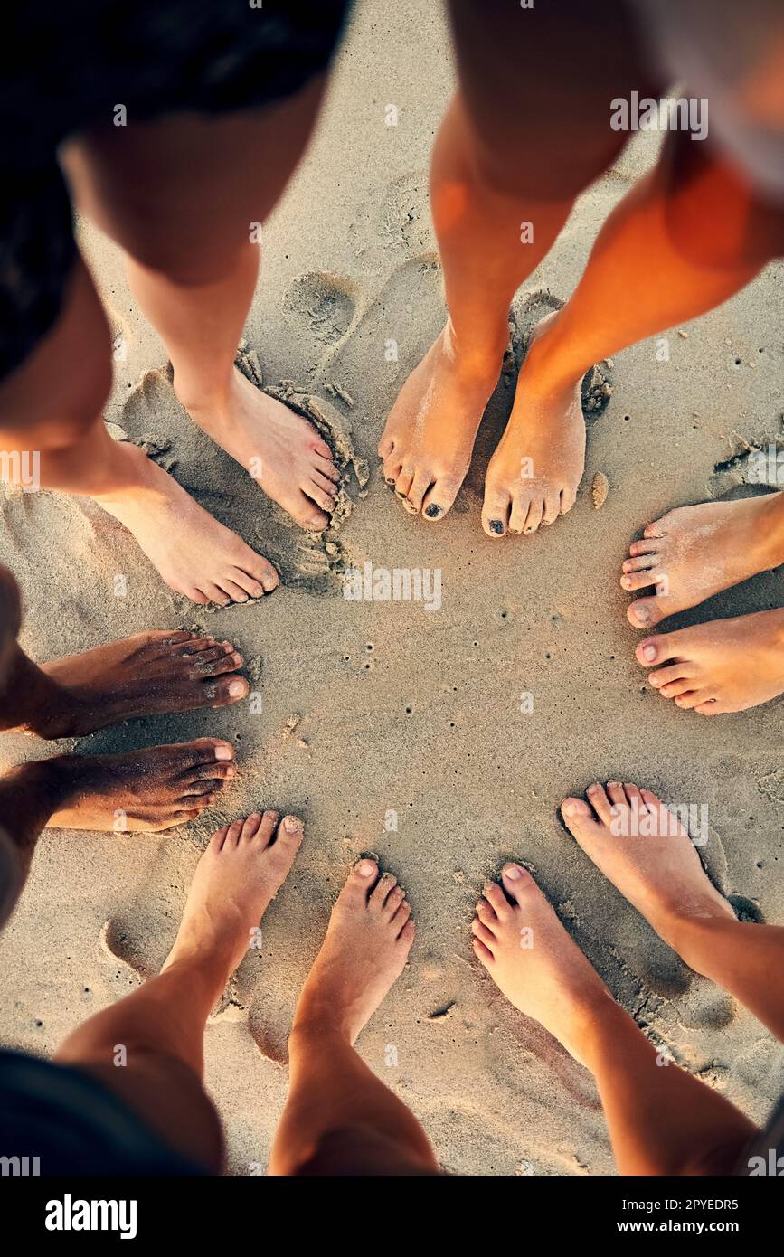 Peace, love and sandy feet. young people hanging out at the beach. Stock Photo