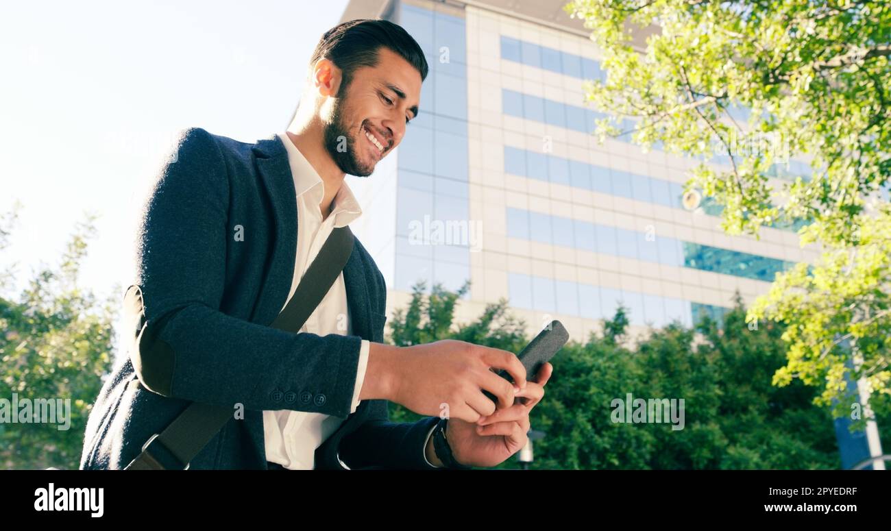 Keeping you connected on every business trip. a handsome young businessman using his cellphone while commuting to work on his bicycle. Stock Photo