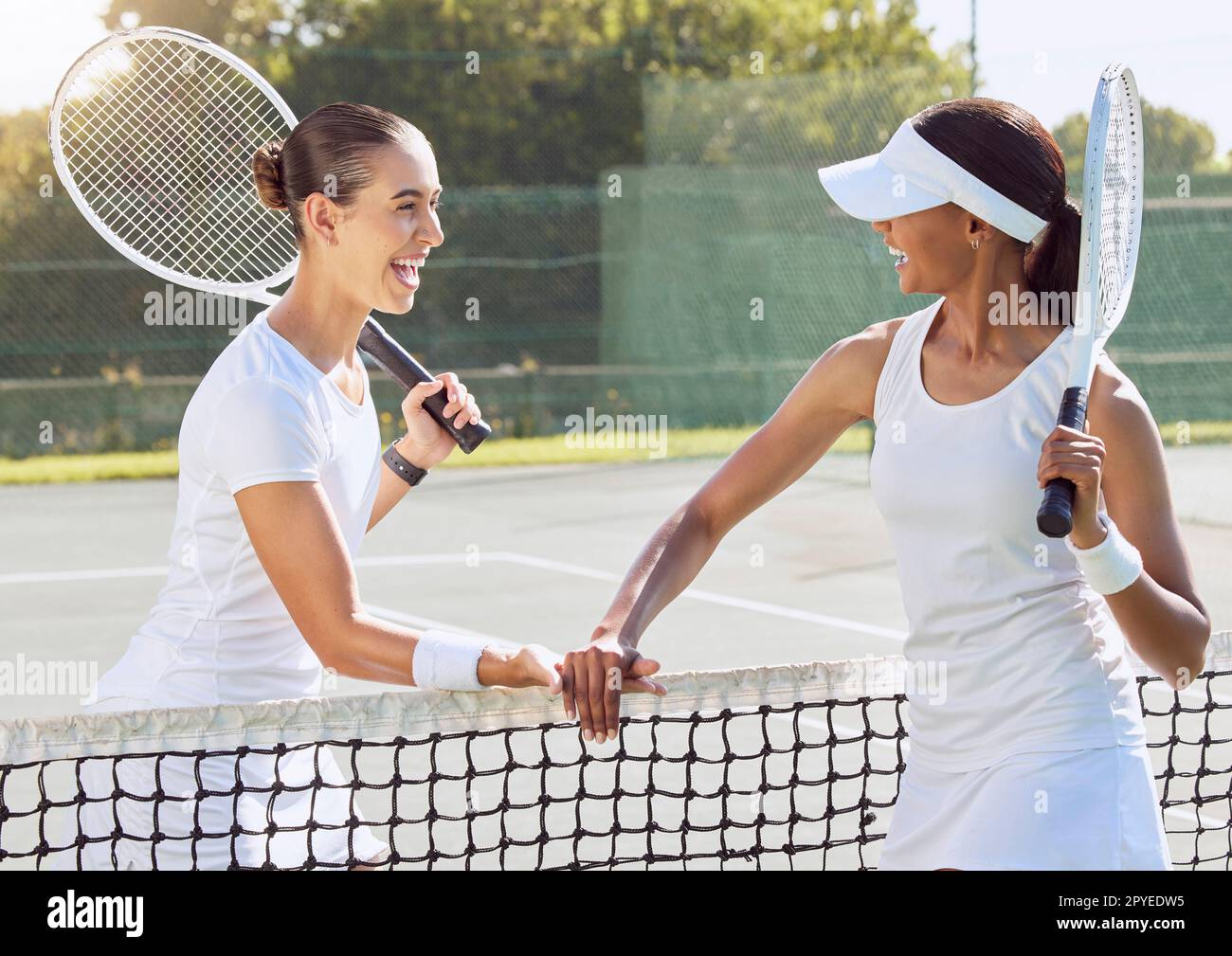 Tennis, friends and match in sports fitness and training for friendly game at the outdoor court. Happy women in sport competition holding rackets for fun workout or exercise together in sportsmanship Stock Photo