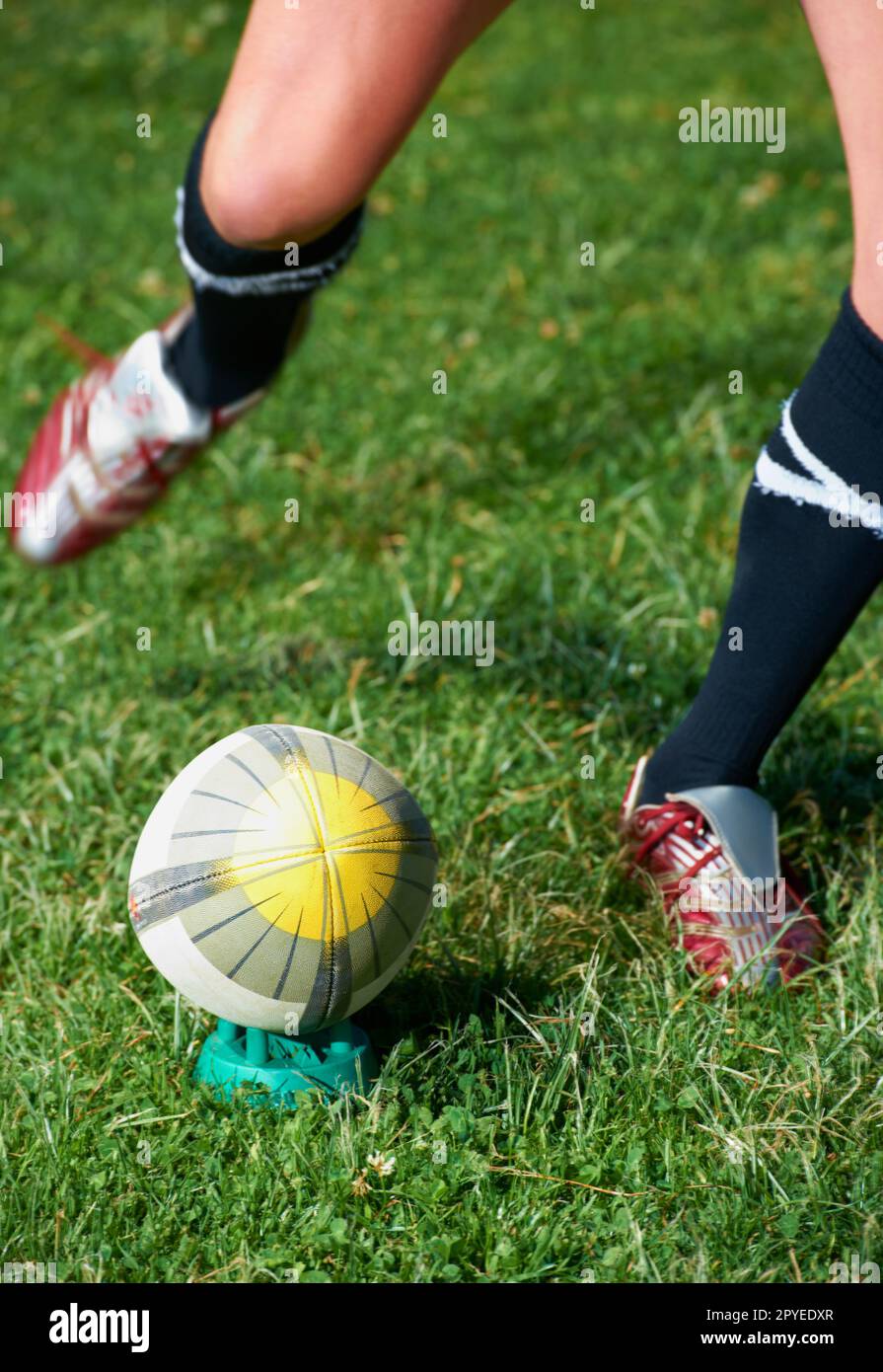 Its a mans sport. a rugby player kicking a ball. Stock Photo