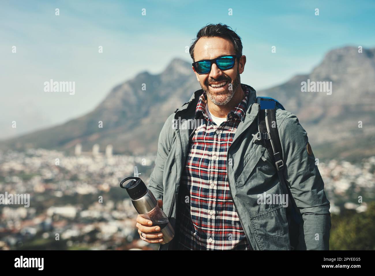 What a wonderful trip its been. Portrait of a middle aged man smiling in front of a mountain landscape. Stock Photo