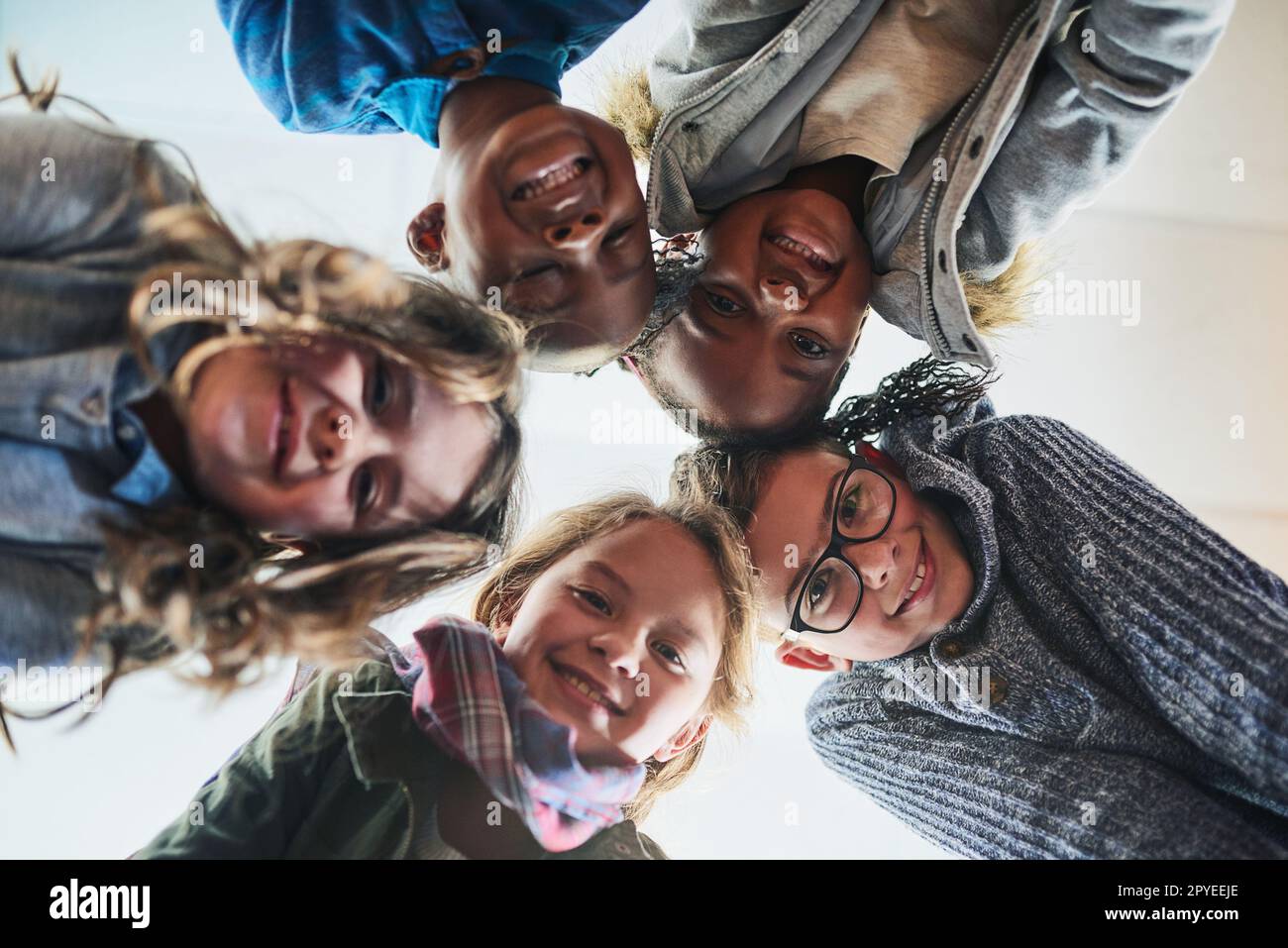 Schools the best with friends like these. Portrait of a group of elementary school kids standing in a huddle. Stock Photo