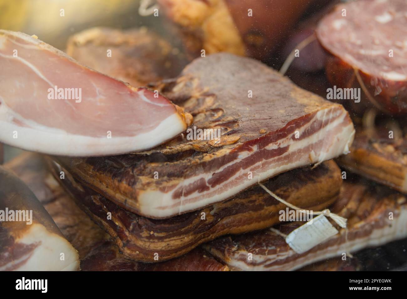 Smoked ham with cured bacon. Hams and bacon are ready for sale at the