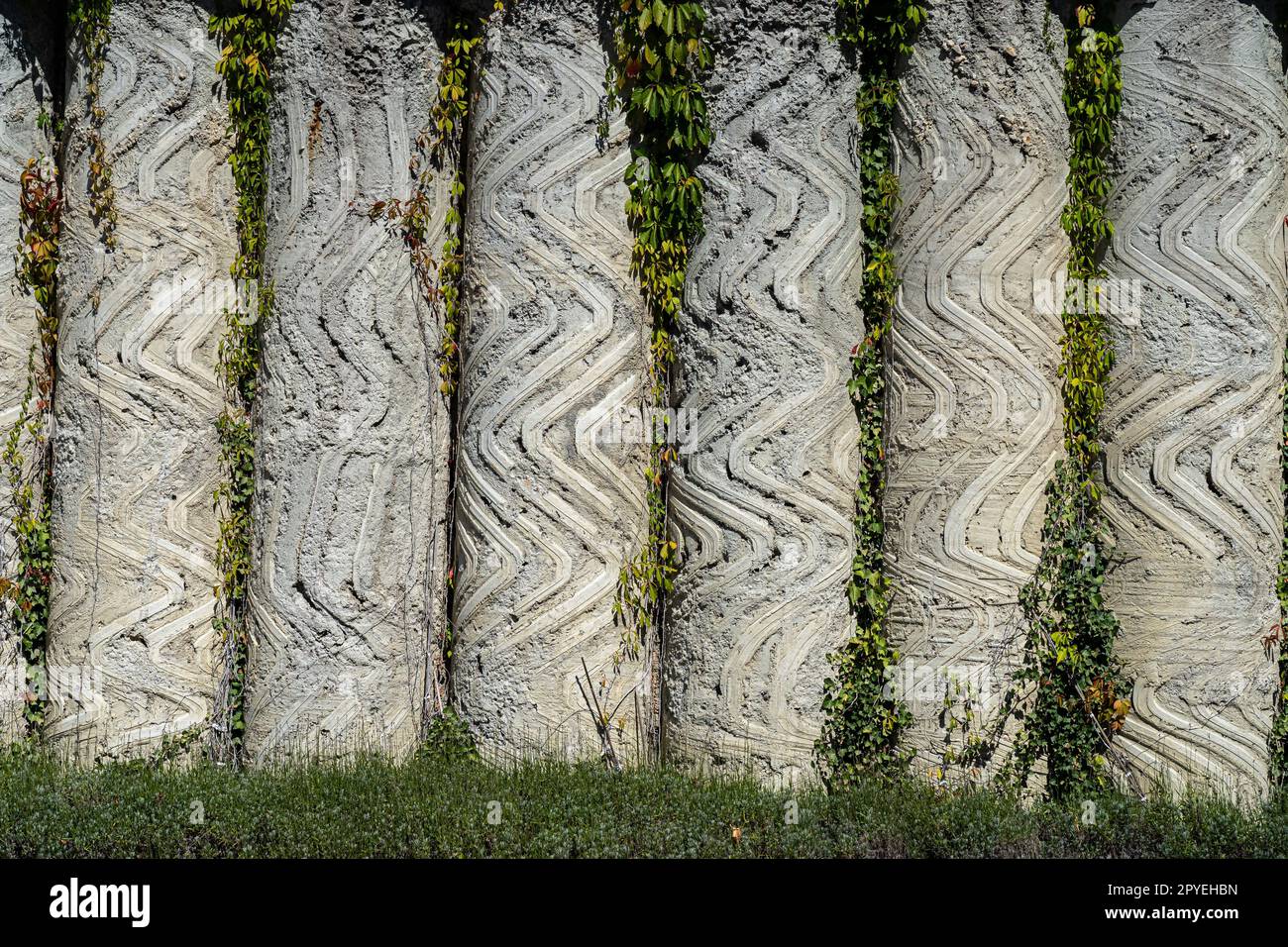Artful wall made of congrete columns outside Stock Photo