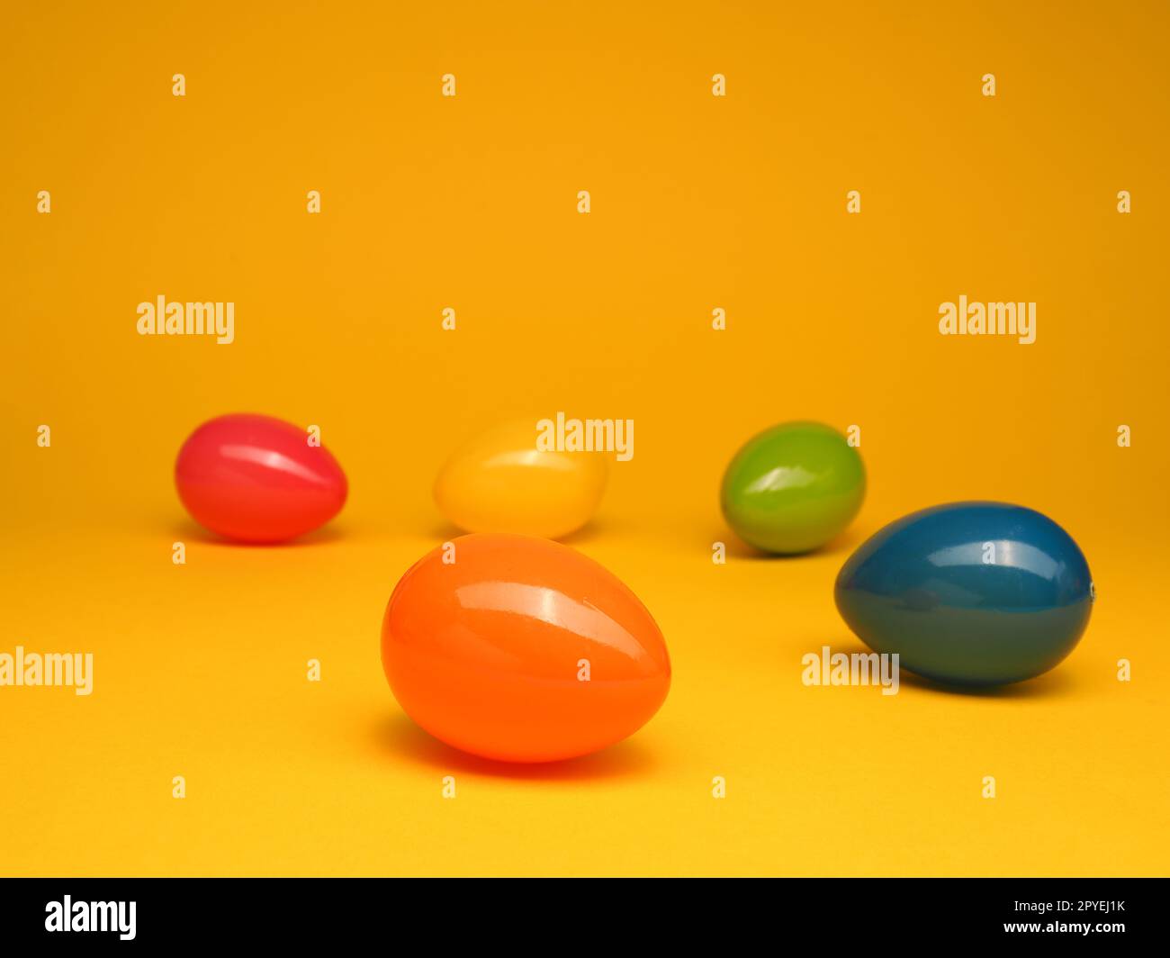 Colorful plastic Easter eggs on a yellow studio background Stock Photo