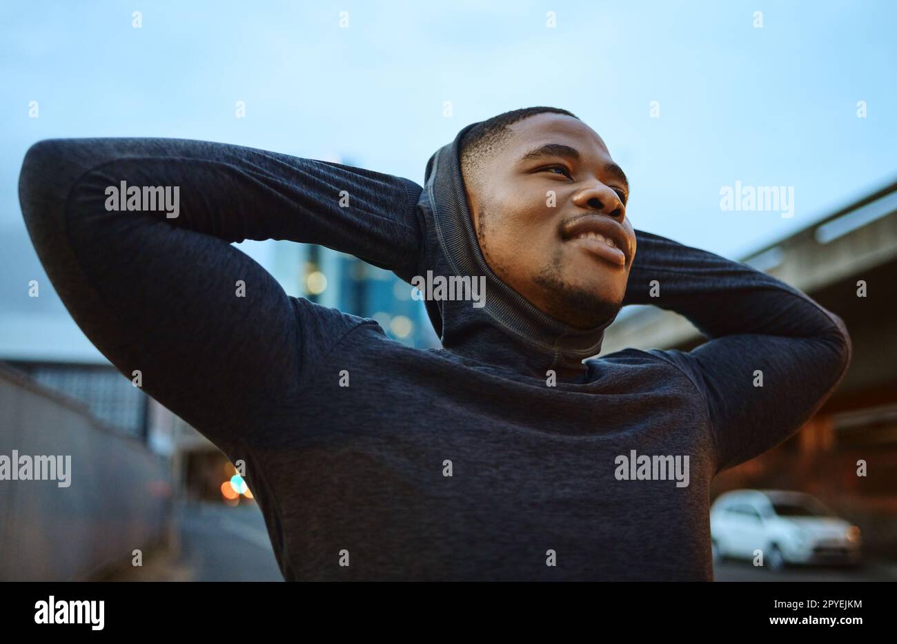 Running, fitness and city with a sports black man taking a rest during his exercise or workout in the evening. Training, health and break with a male runner or athlete in an urban town for cardio Stock Photo