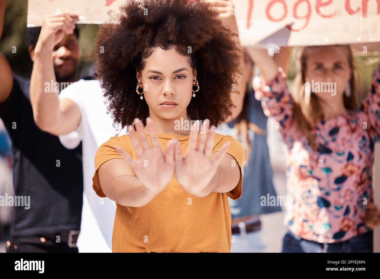 Protest, hands and stop with a black woman activist in demonstration with a group of people ready to fight for freedom. Community, politics and rally with a young female standing against violence Stock Photo