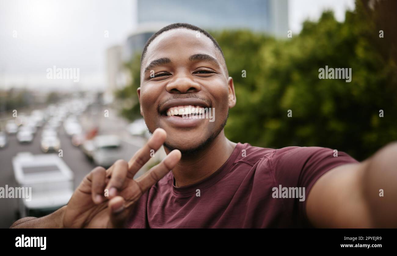Man, face or peace sign on fitness selfie in city workout, training or exercise success for Nigerian wellness, marathon or sports. Portrait, smile or happy runner in photography pov or hand gesture Stock Photo