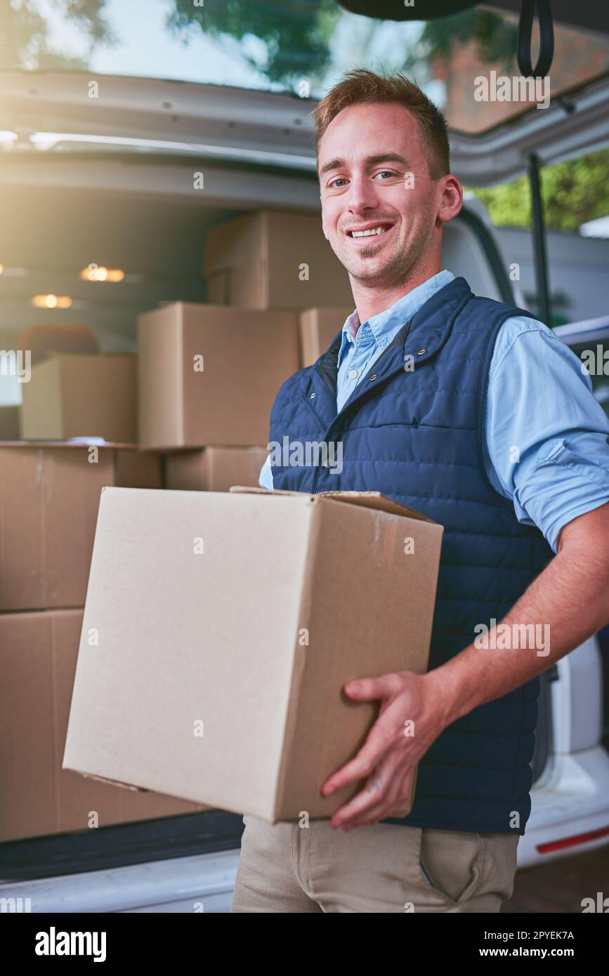 Ive got your parcel safely right here. Portrait of a courier standing alongside his delivery van. Stock Photo
