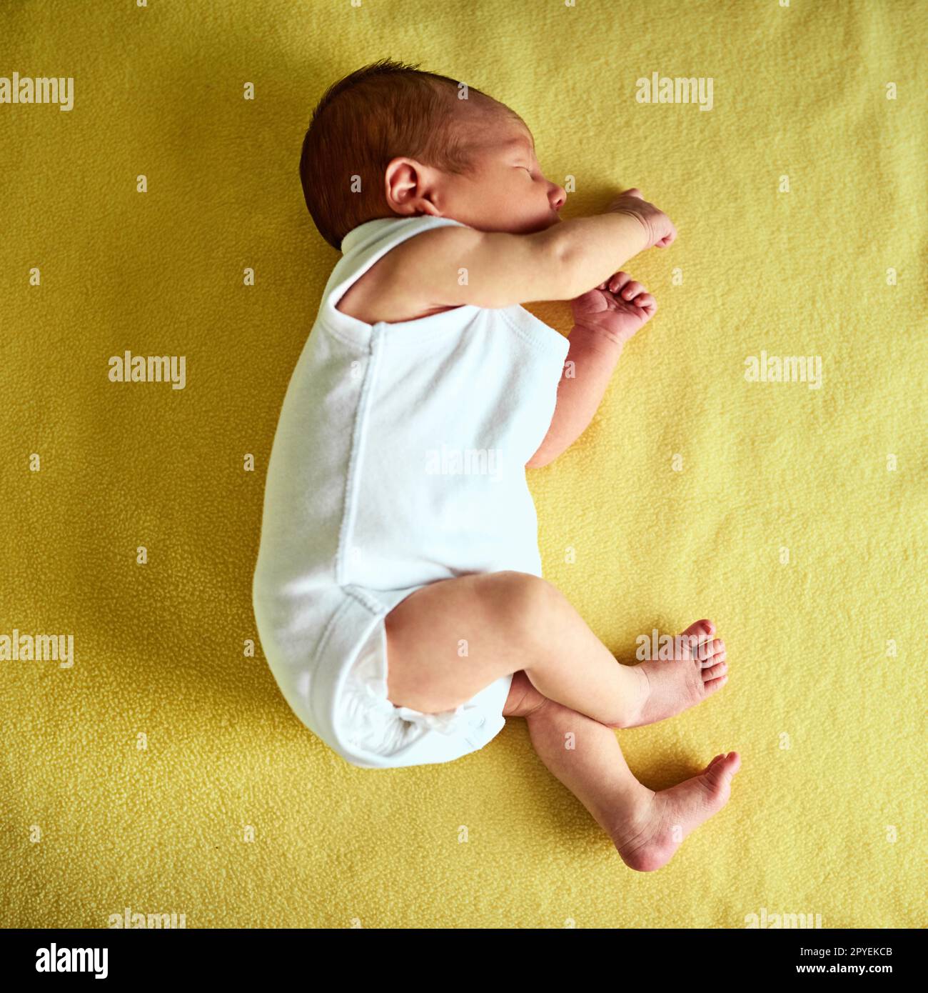 Already sleeping like a grownup. a tired little baby boy sleeping with his eyes closed on a bed at home. Stock Photo