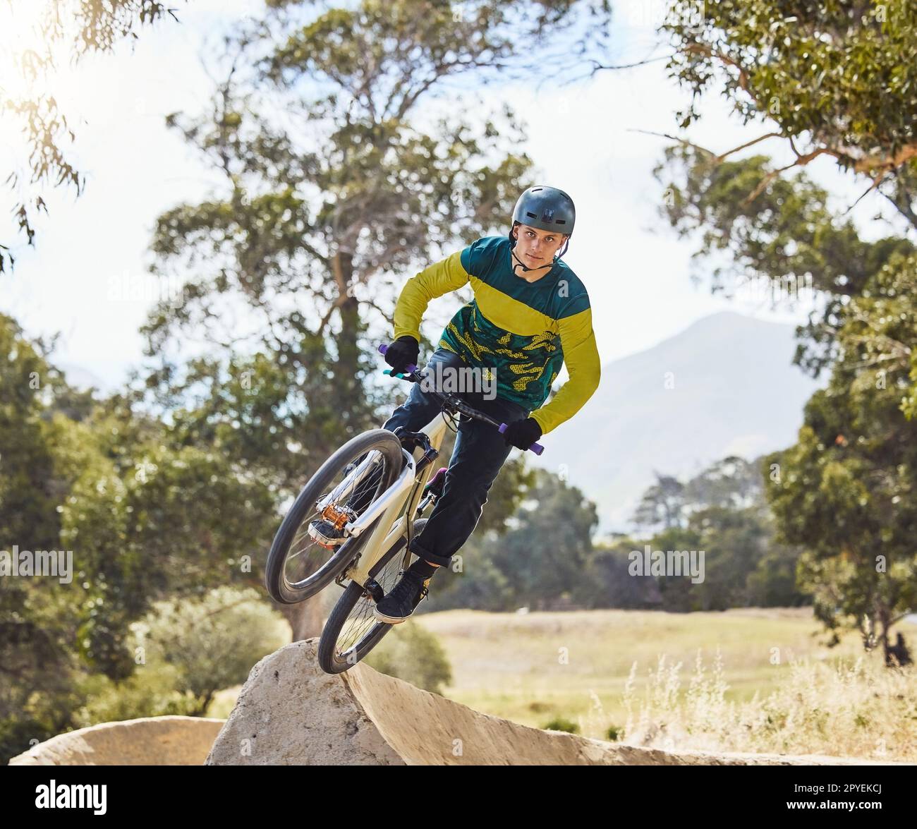 Mountain bike man, air ramp and outdoor with helmet, extreme sport and focus for fitness, speed and training. Bmx bicycle. sports expert and fast jump in nature, trail and cycling for competition Stock Photo
