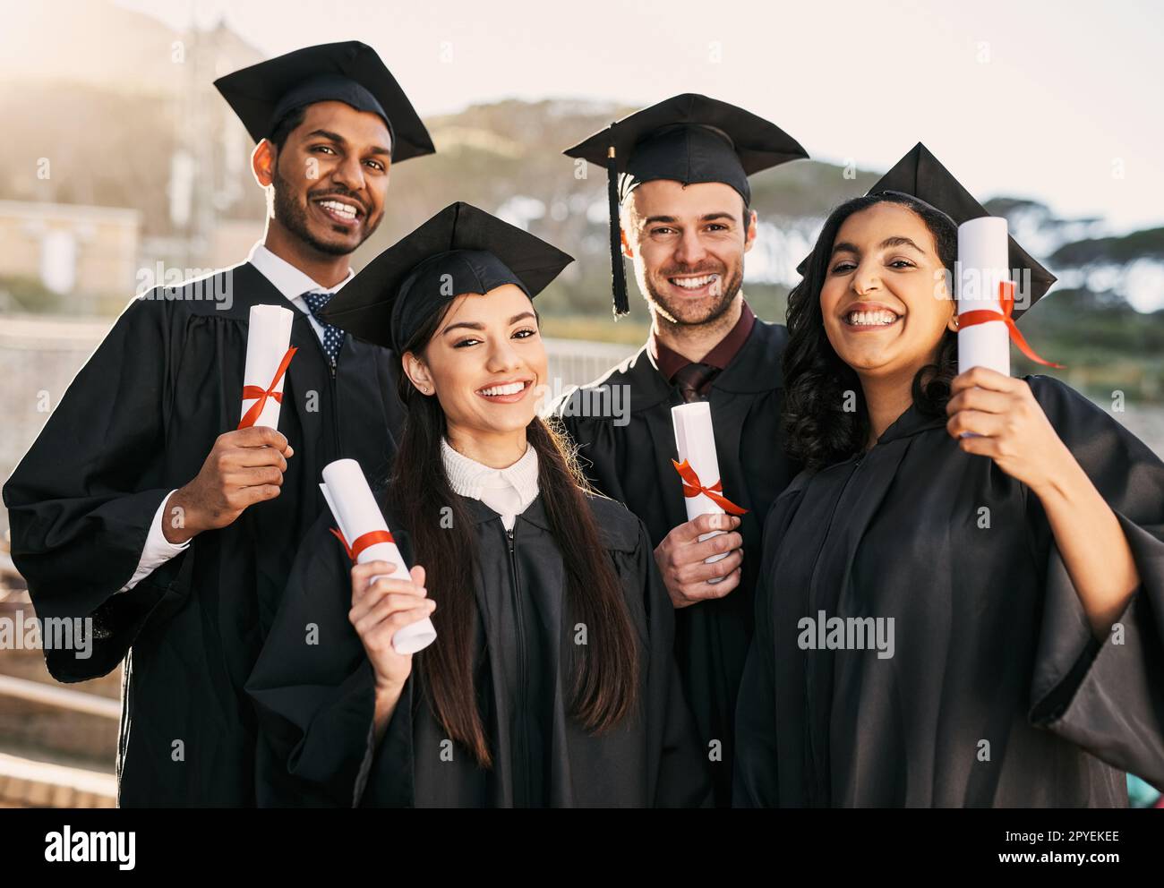 Successful careers - here we come. Portrait of a group of students celebrating with their diplomas on graduation day. Stock Photo