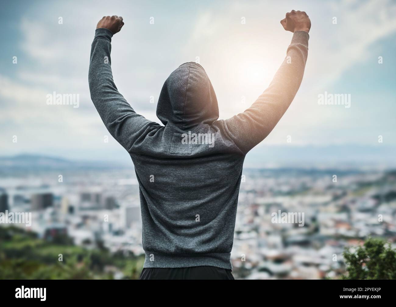 Ill take on the world. Rearview shot of an unrecognizable young sportsman cheering in celebration outside. Stock Photo