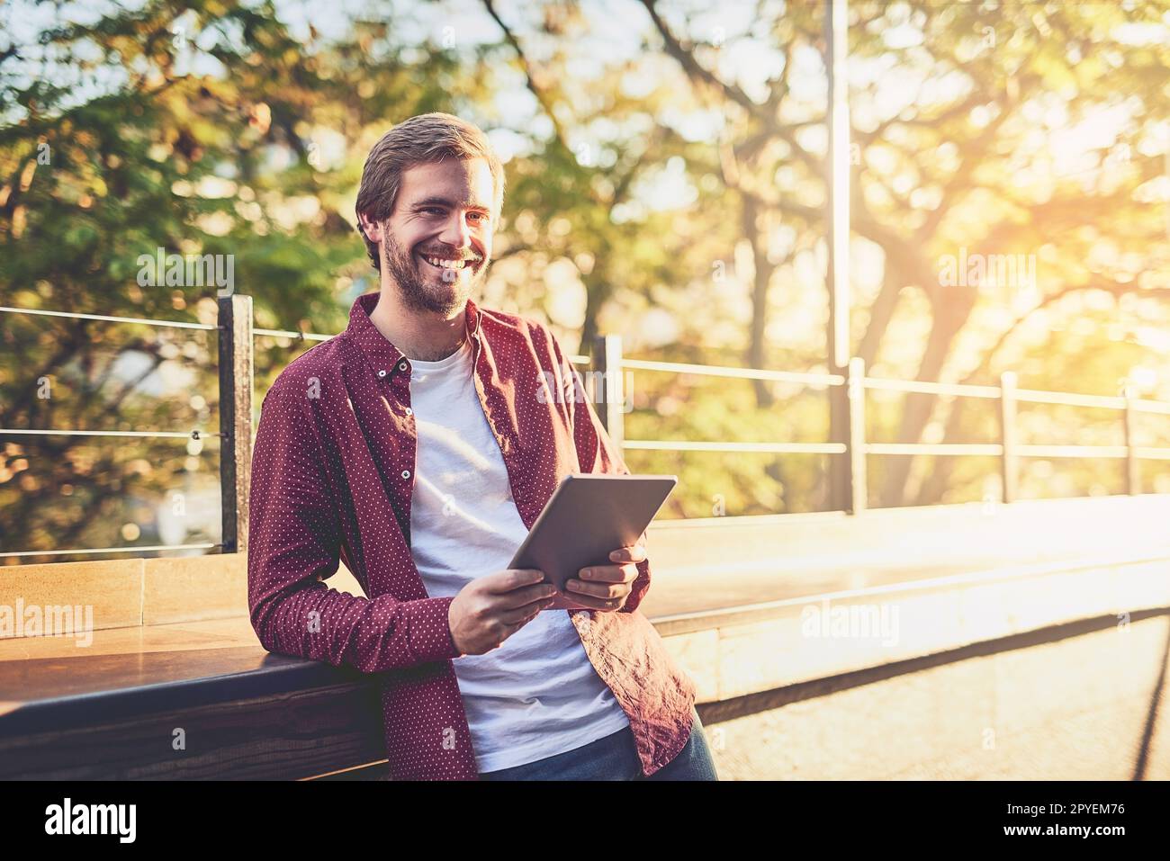 I found myself a device that meets my digital needs. a handsome man using his digital tablet outside. Stock Photo
