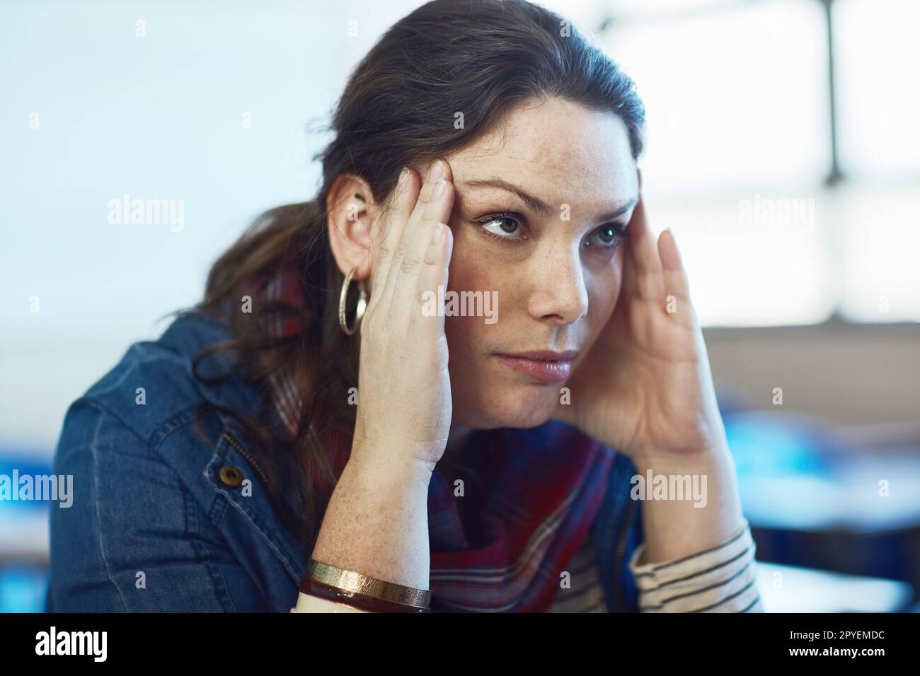 The stress is getting to her. a university student looking stressed out at campus. Stock Photo