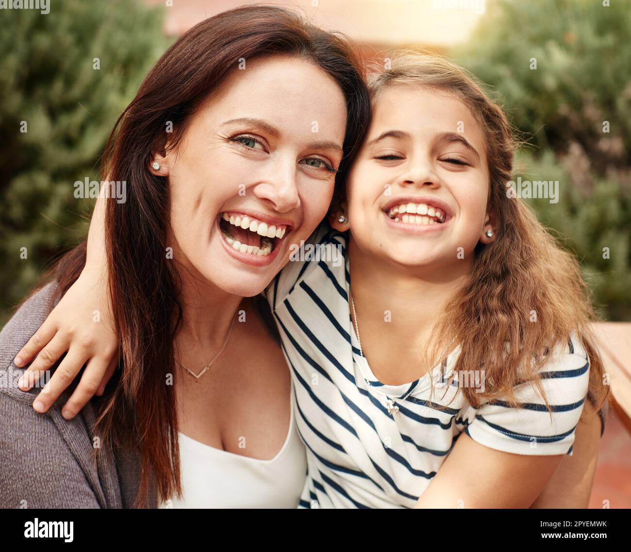 You can see where she gets that smile. A happy mother and daughter spending time together outdoors. Stock Photo