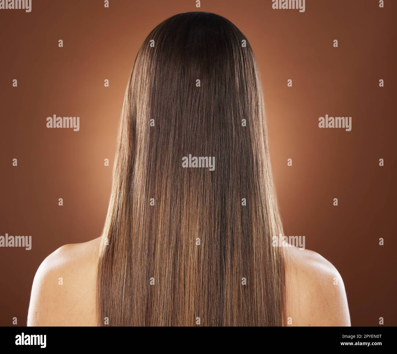 Woman, back or hair style on brown background in relax studio for keratin treatment, self care wellness or color dye routine. Model, texture or brunette growth aesthetic with balayage transformation Stock Photo