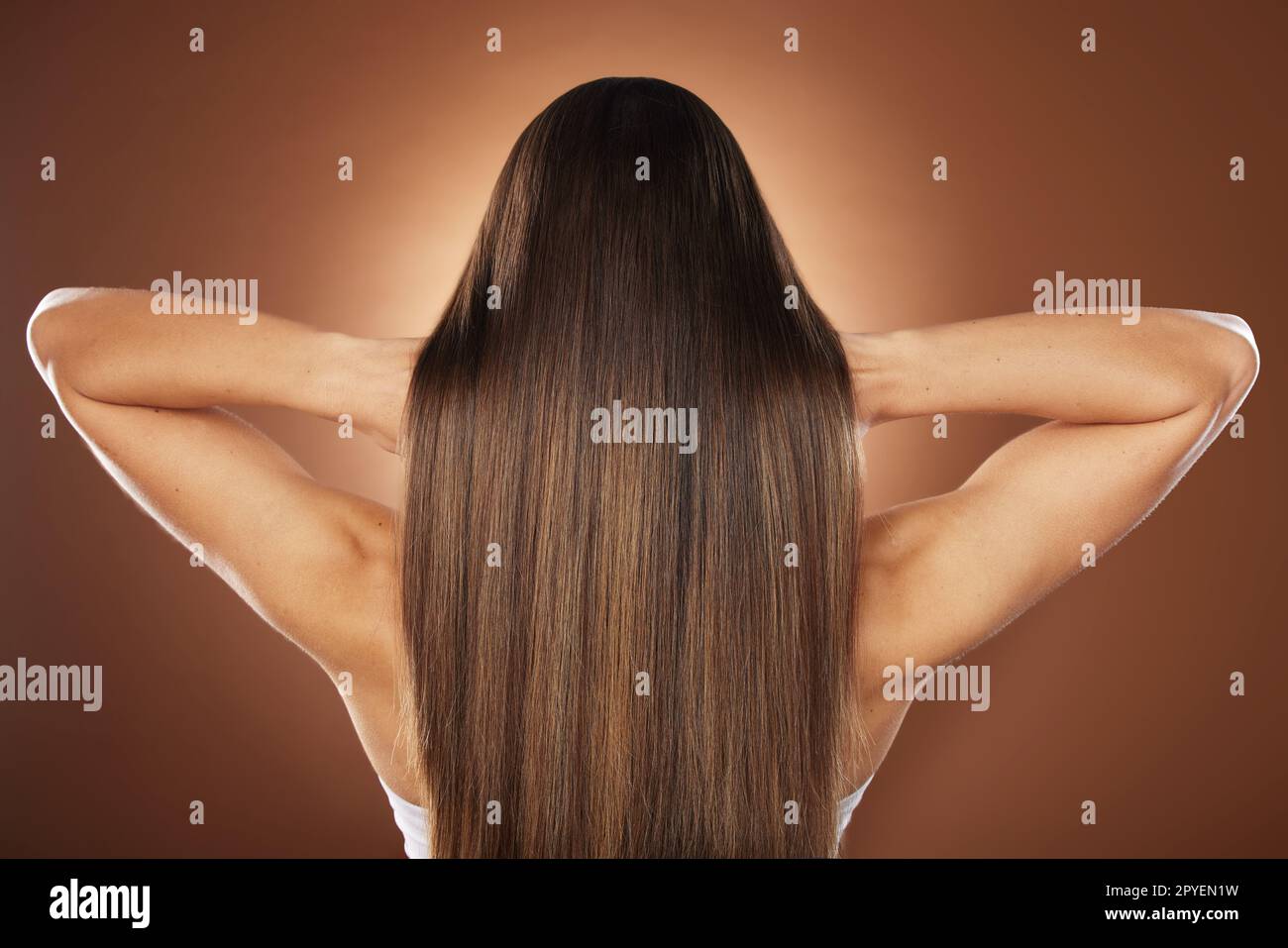 Woman, back or hair style on brown background in relax studio for keratin treatment, self care wellness or color dye routine. Model, texture or brunette growth aesthetic with balayage transformation Stock Photo