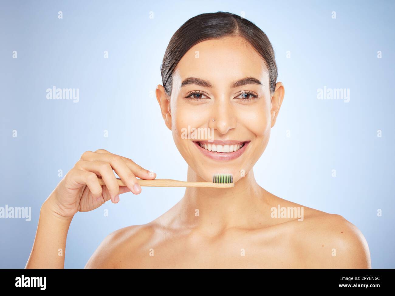 Face portrait, dental and woman with toothbrush in studio isolated on a blue background. Oral wellness, veneers and happy female model holding product for brushing teeth, cleaning and oral hygiene. Stock Photo