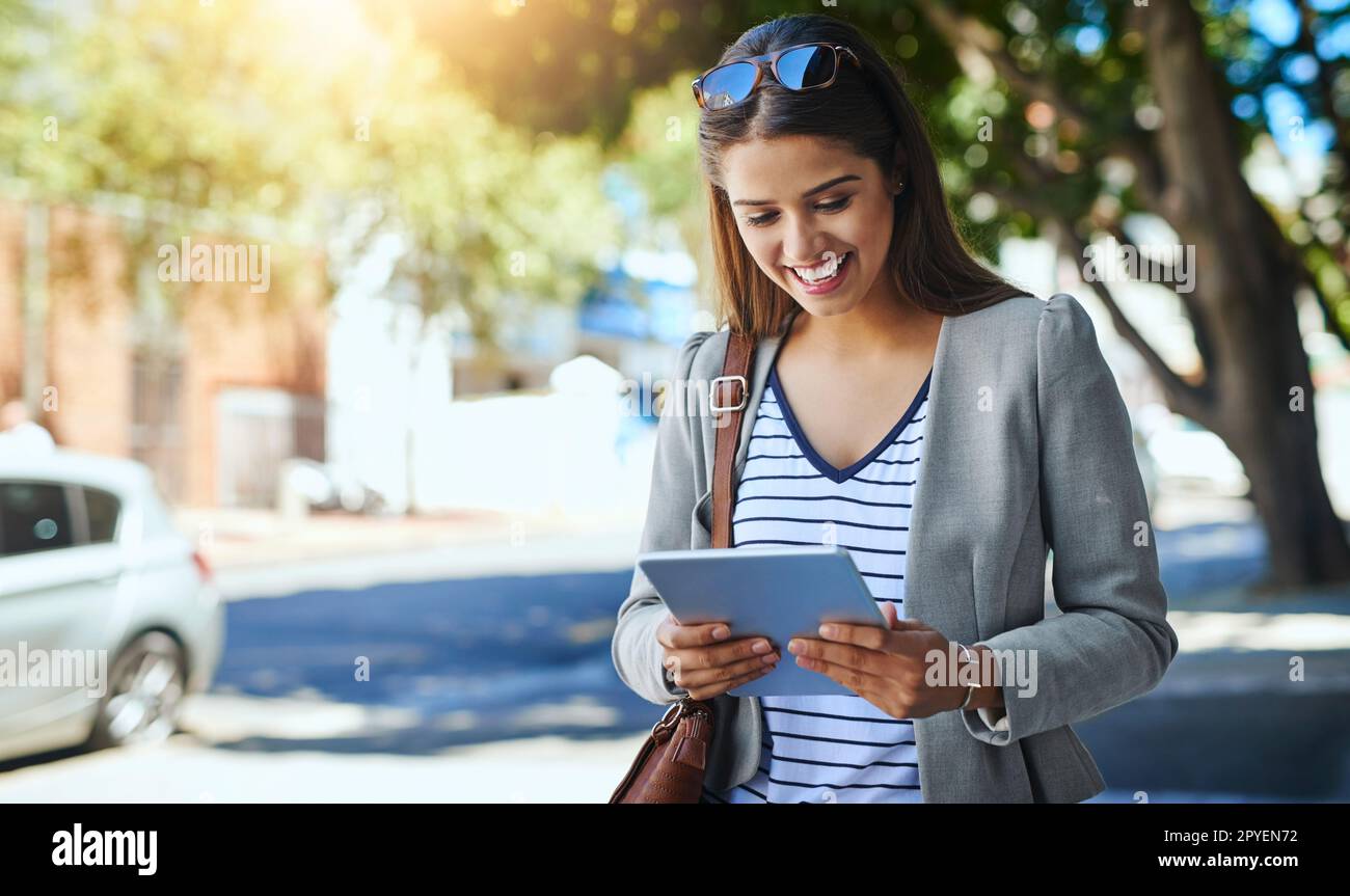 Working on her way. an attractive young woman using her tablet while commuting to work. Stock Photo