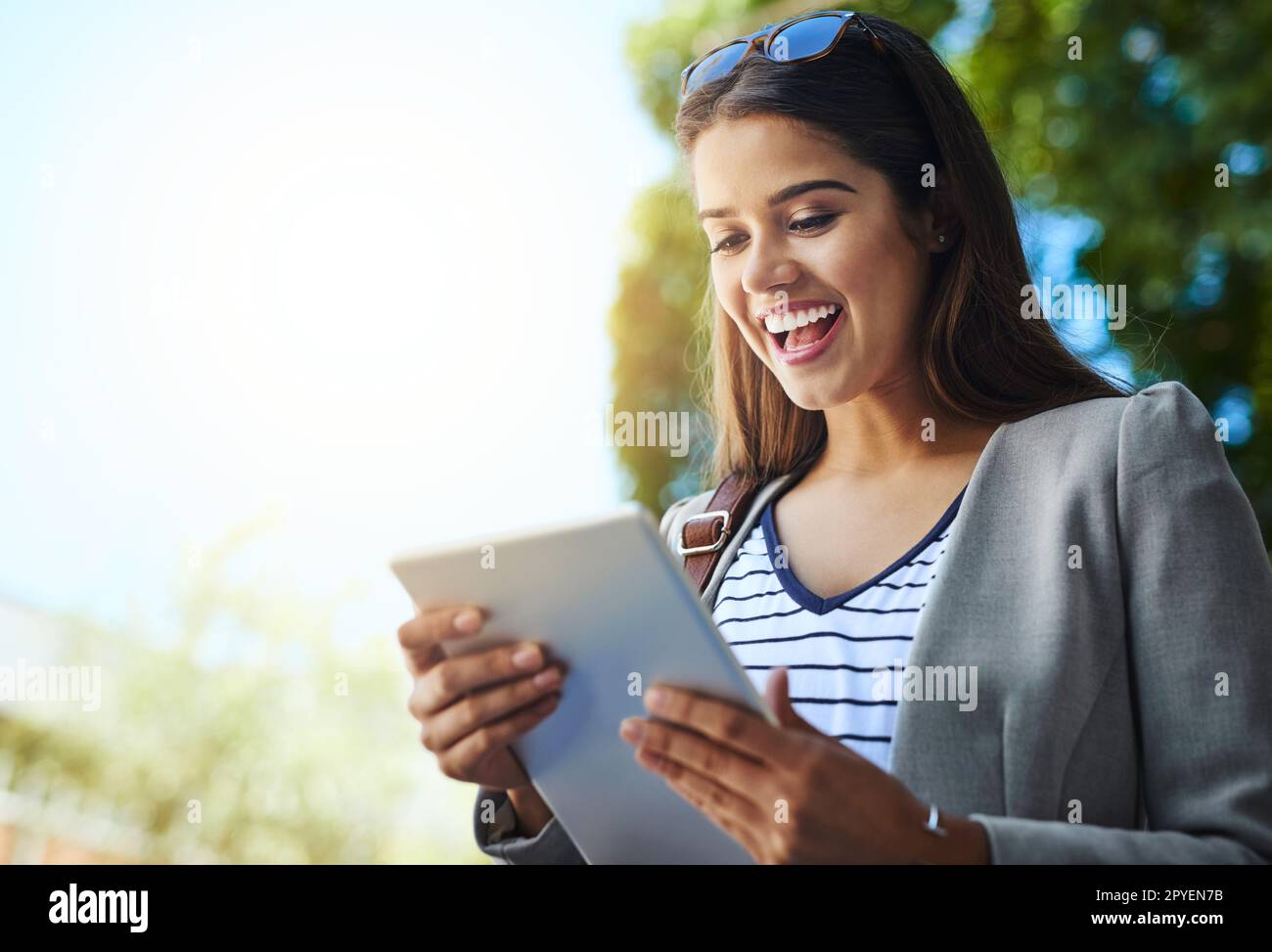 She doesnt need an office to do business. an attractive young woman using her tablet while commuting to work. Stock Photo