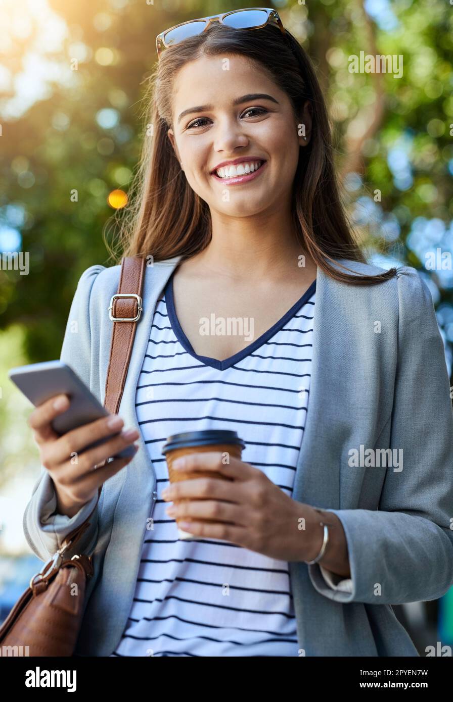 Im always in contact with the office. Cropped portrait of an attractive young woman using her cellphone while commuting to work. Stock Photo