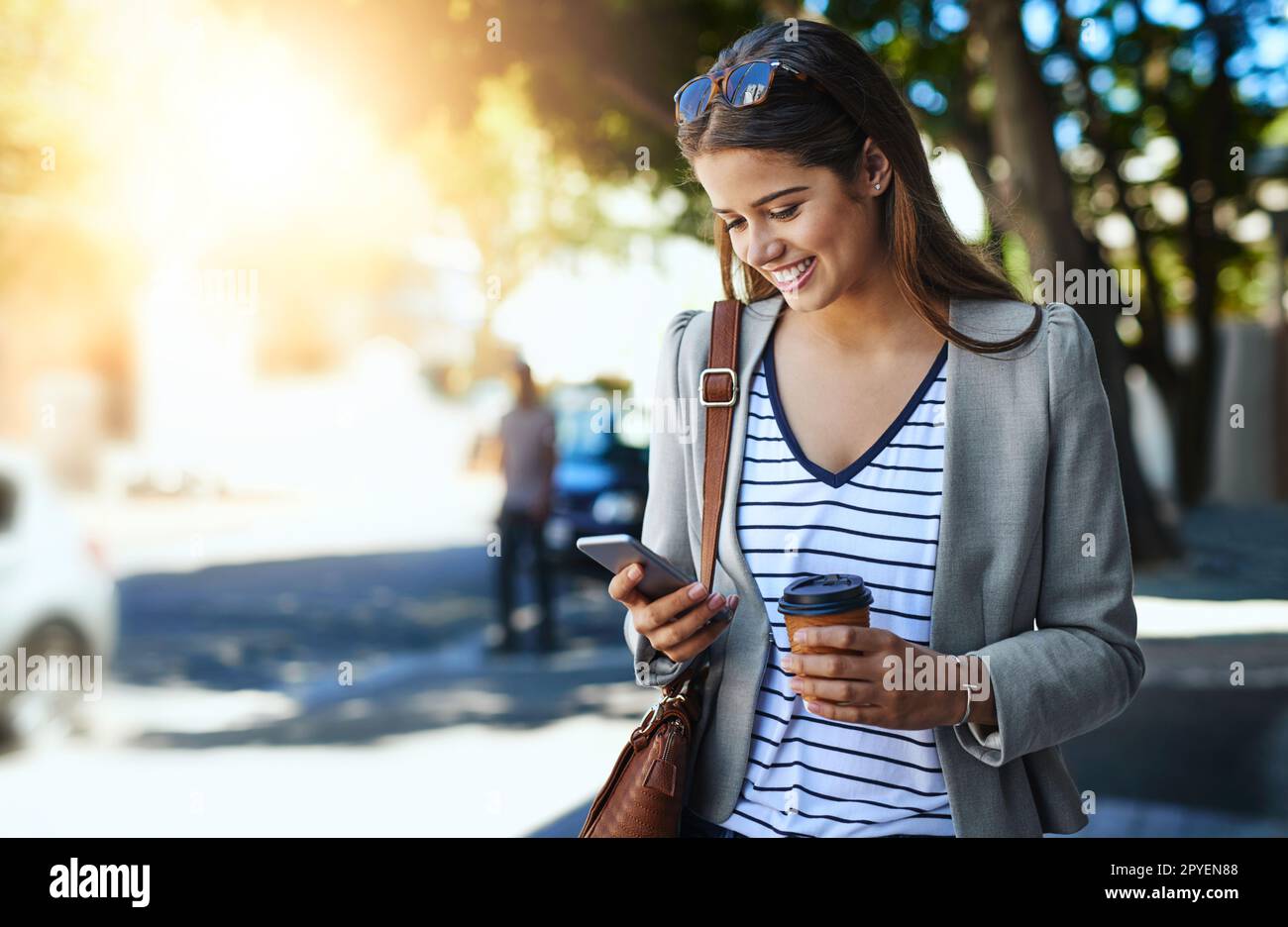 Shes always available to colleagues and clients. an attractive young woman using her cellphone while commuting to work. Stock Photo