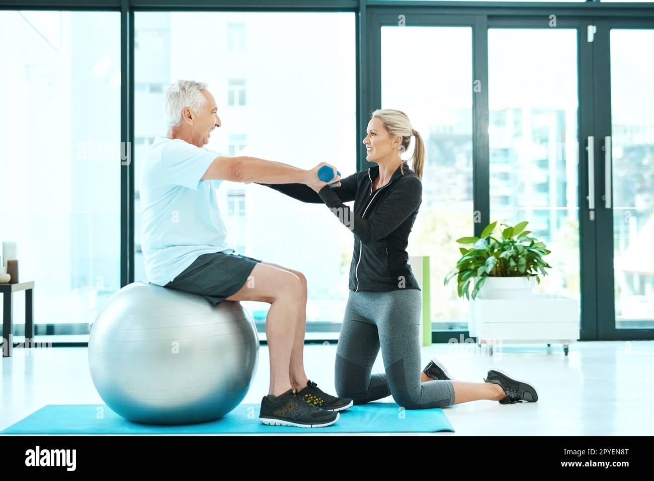 Just tell me when you feel discomfort...a senior man working out in a rehabilitation center. Stock Photo