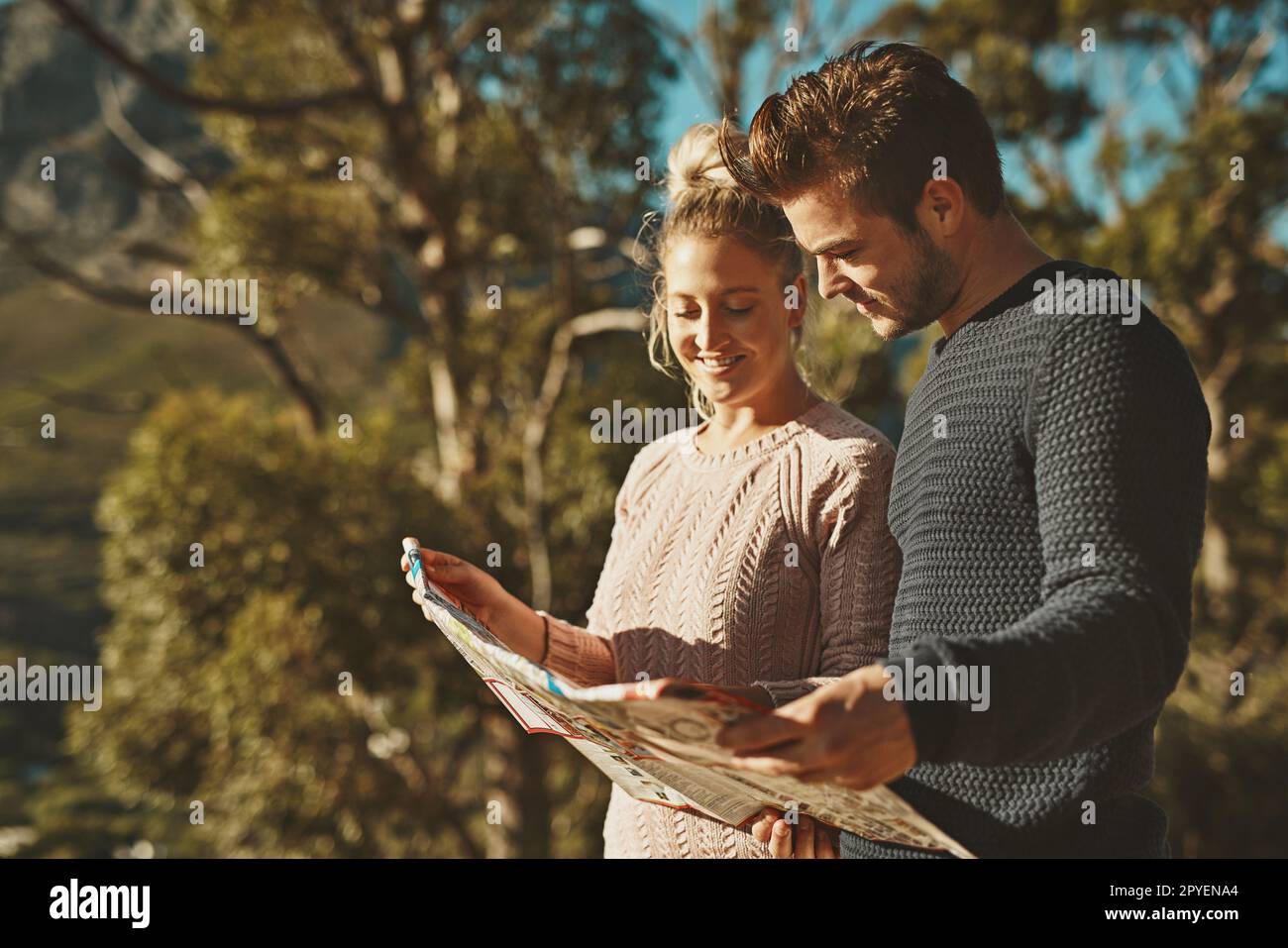 Wherere we heading. a young couple looking at a map while out hiking. Stock Photo