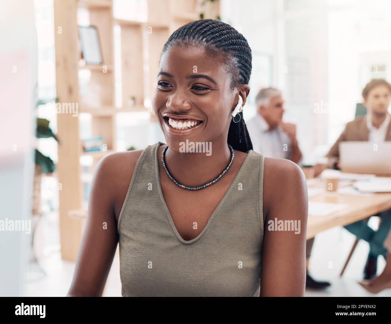 Music, podcast and woman at computer with earphones in office with streaming service while working. Work, smile and happy black woman listening to streaming radio station app online in modern office. Stock Photo