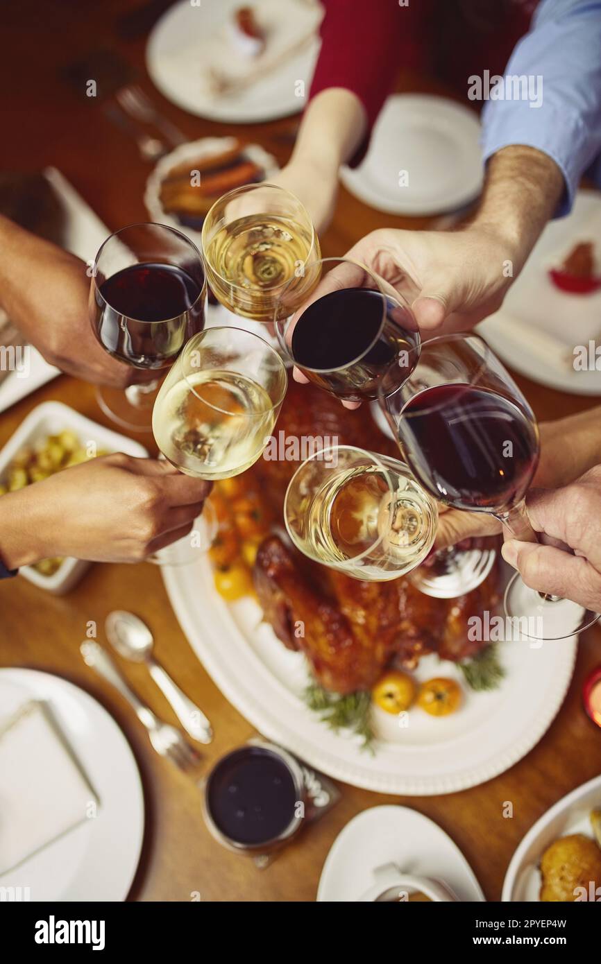 Cheers to many moments of joy. Closeup shot of a group of people making a toast at a dining table. Stock Photo